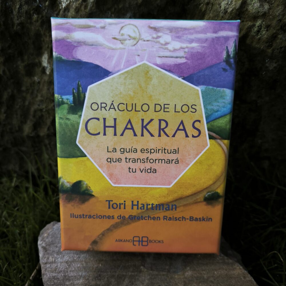 Caja del Oráculo de los Chakras de Tori Hartman con paisaje ilustrado en tonos amarillos y violetas.